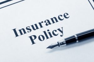 A pen on top of an insurance policy document. Importance of the right types of insurance coverage need if you are in an auto accident or car crash.